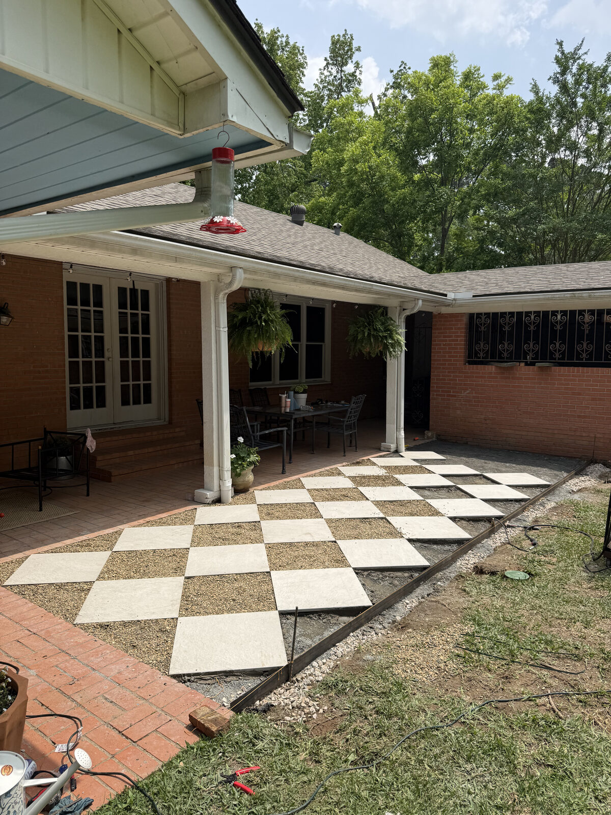 Checkerboard concrete paver patio installation in progress in East Texas