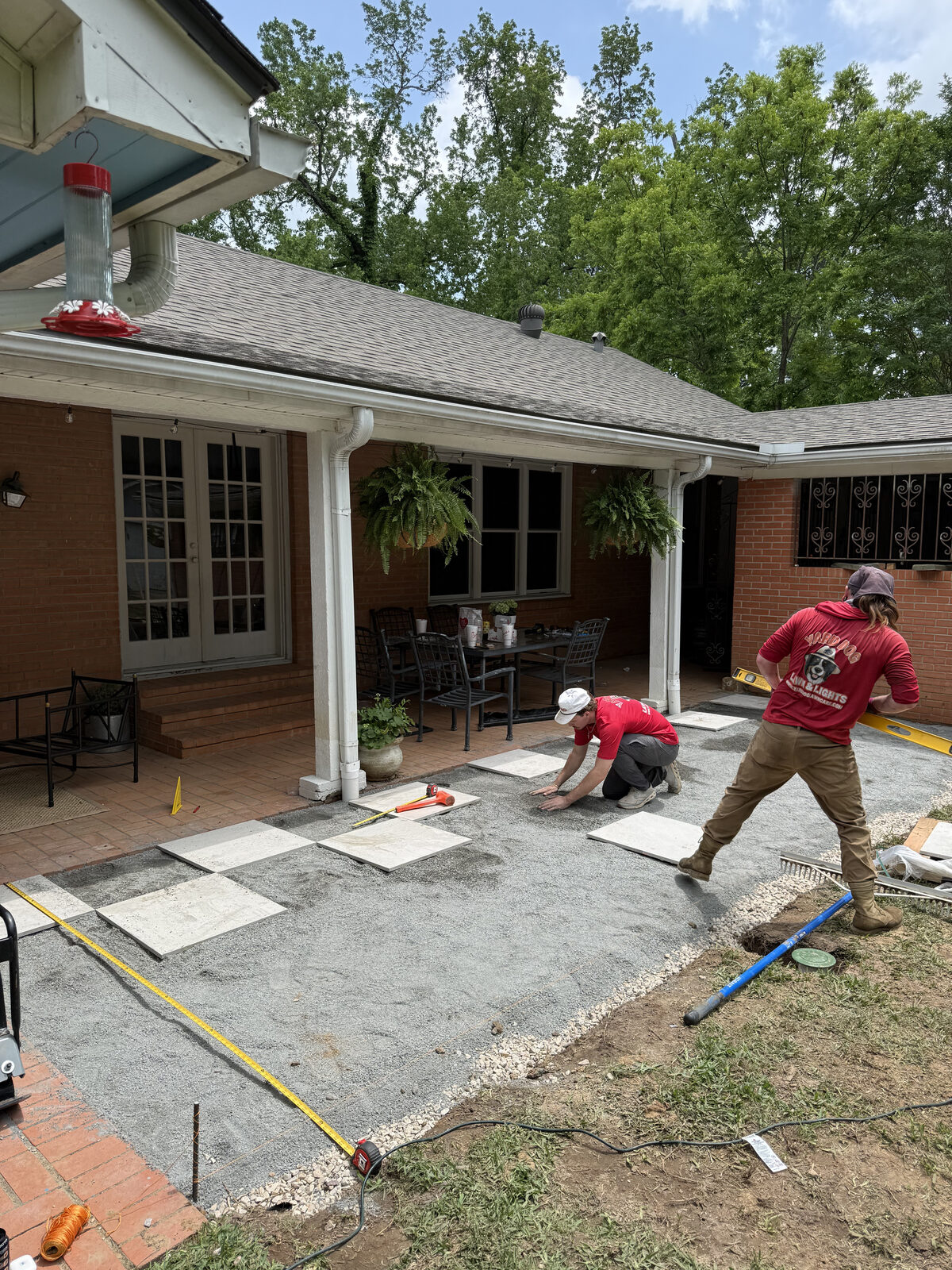 Concrete pavers laid out in a checkerboard pattern during a patio install in East Texas