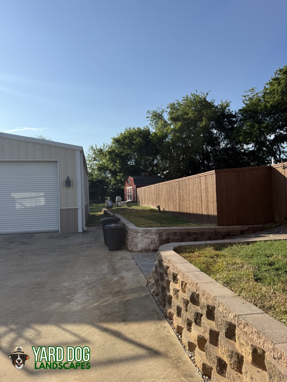 Completed curved block retaining wall with a gravel drainage strip in East Texas