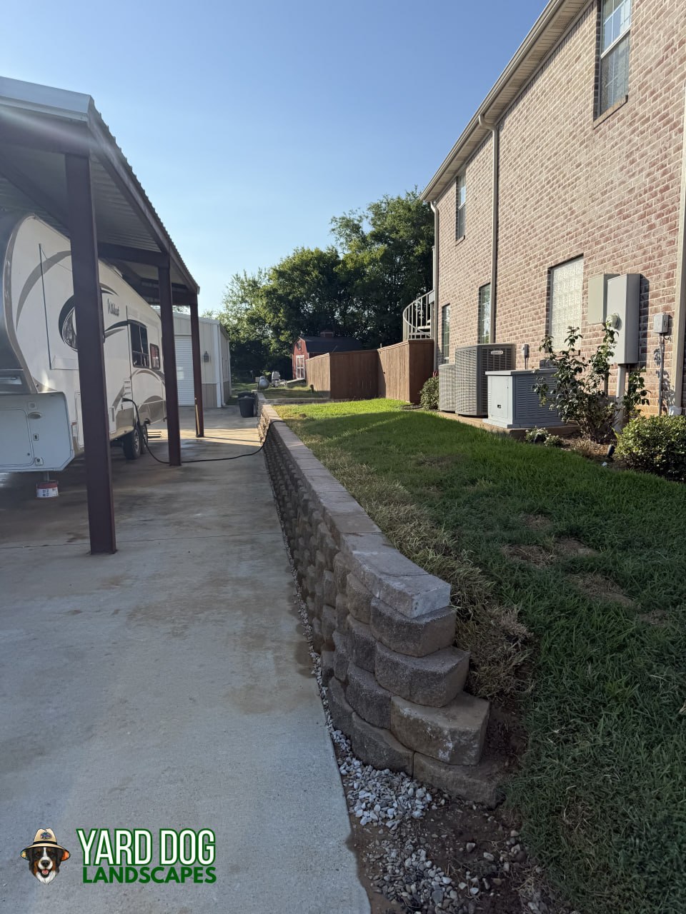 Finished segmental block retaining wall along a concrete driveway in East Texas