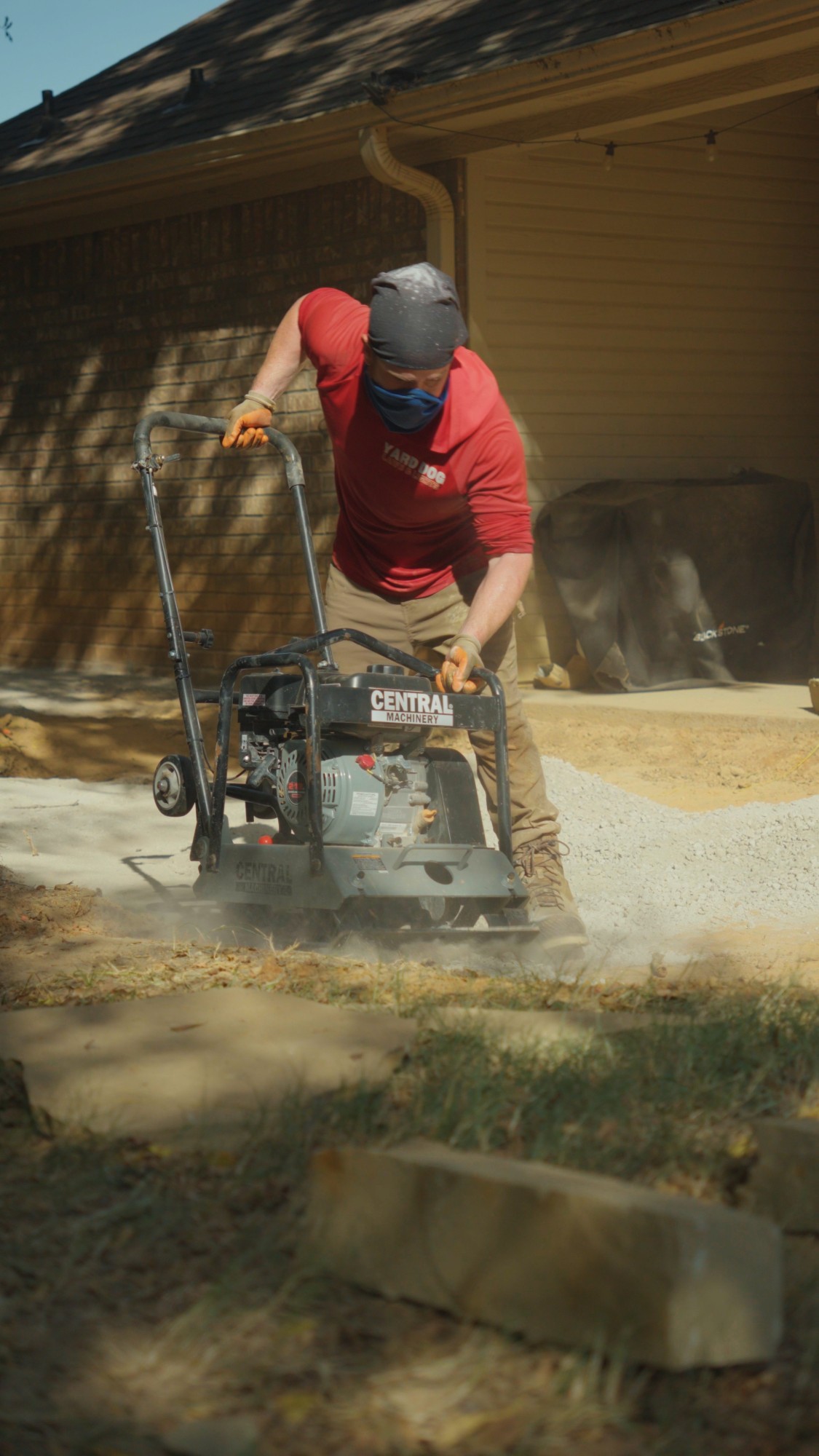 Yard Dog crew member compacting the base for a 475 sq ft flagstone patio in White Oak, TX