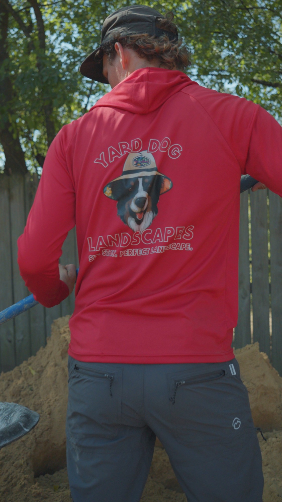 Yard Dog Landscapes crew member shoveling the sand setting bed for a flagstone patio in White Oak, TX