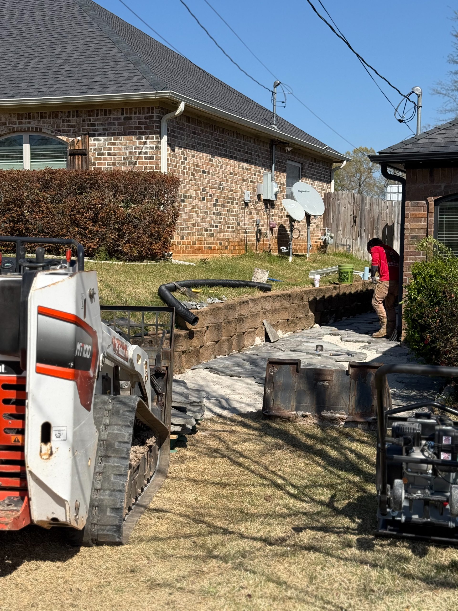 Skid steer working on a paver patio install