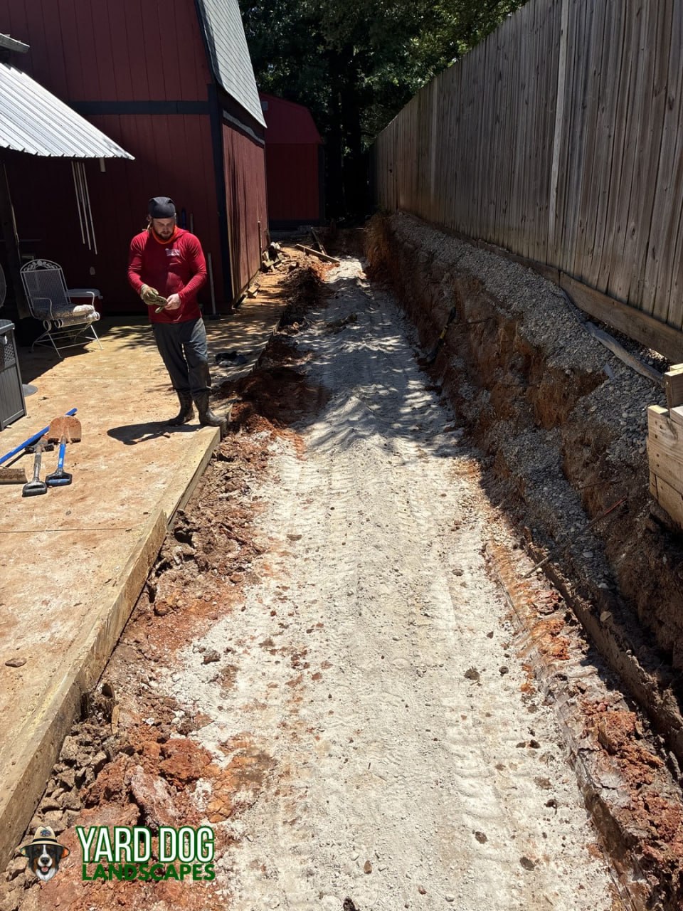 Trench excavated and gravel drainage base prepared for a new block retaining wall in East Texas