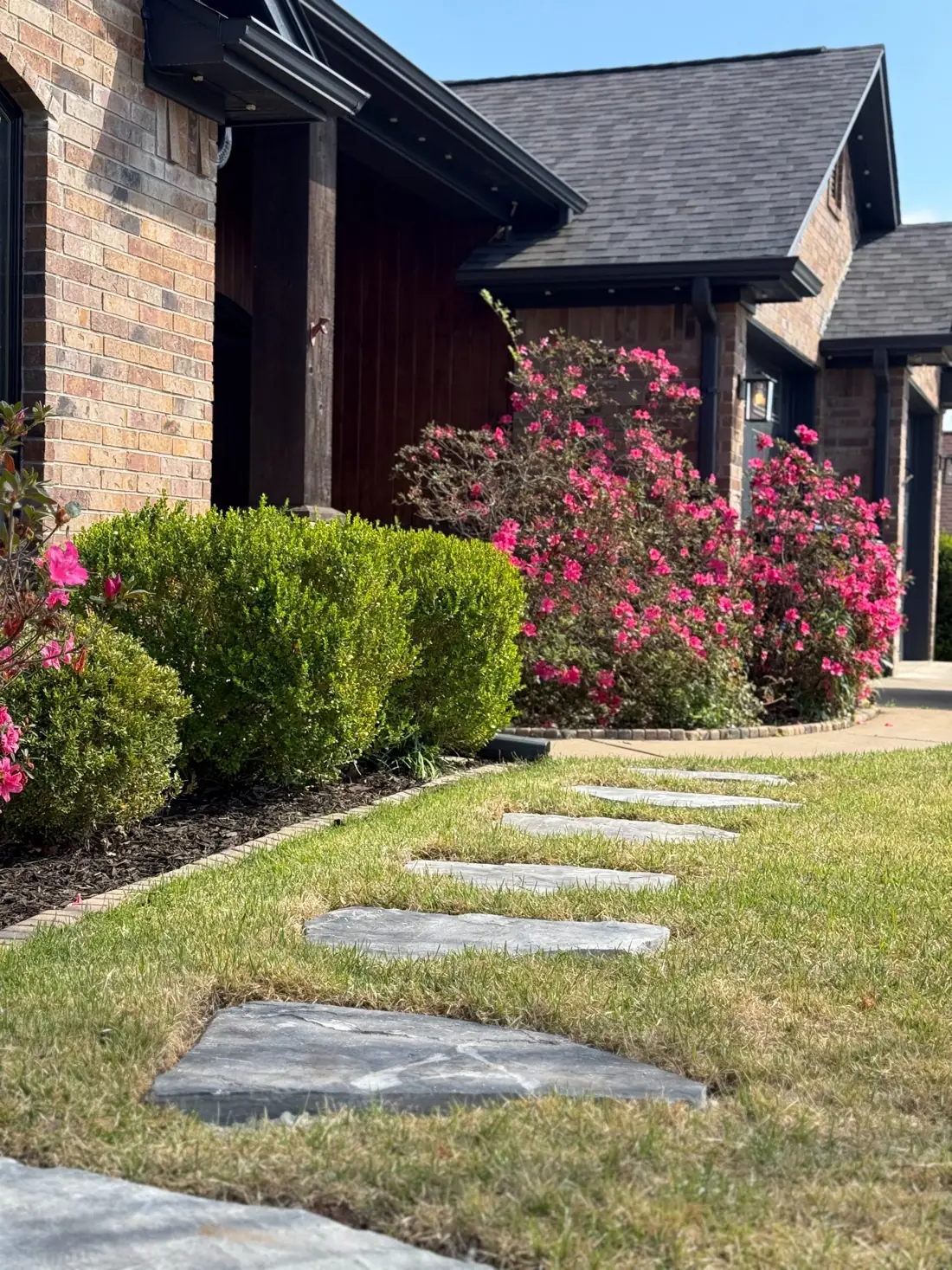 Front yard with healthy bermuda grass and crepe myrtles in bloom along a stepping-stone path