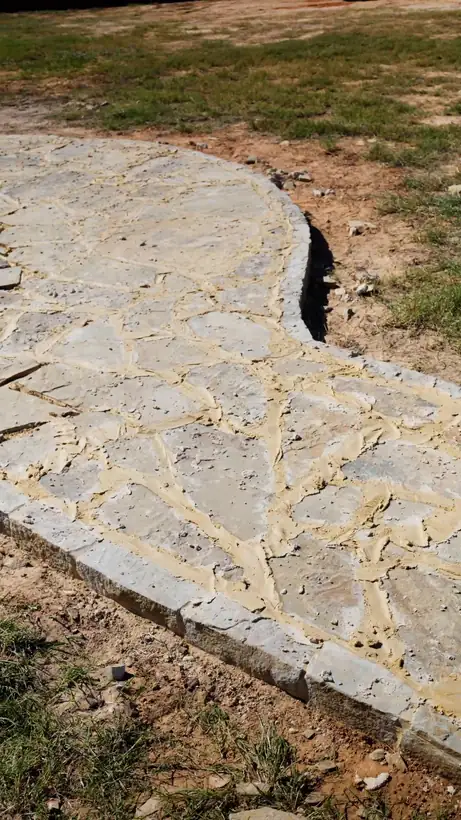 Chopped stone border curving around the new flagstone, Kilgore, TX