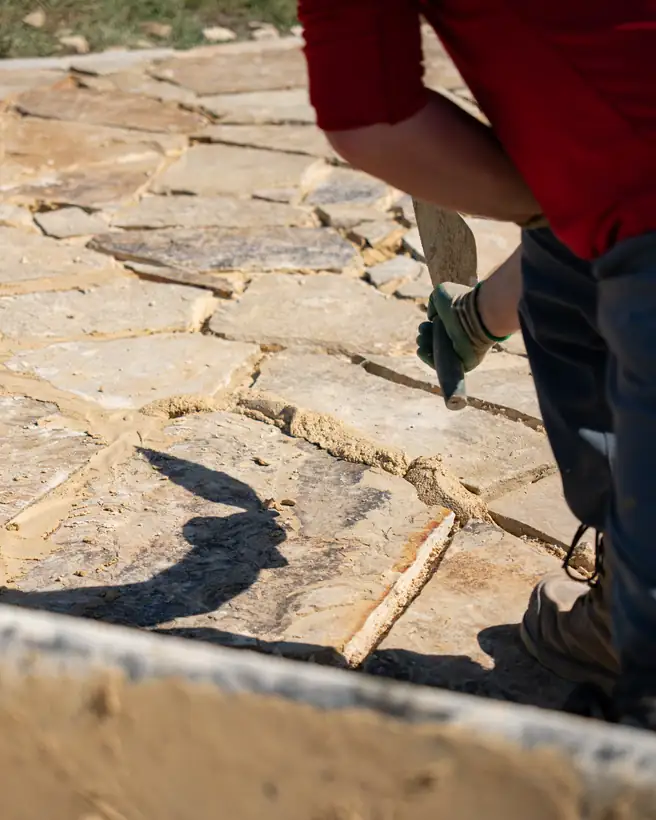 Working mortar into the flagstone joints, Kilgore, TX