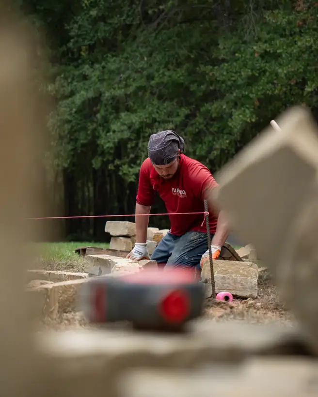 Setting chopped stone border blocks to a string line, Hallsville, TX