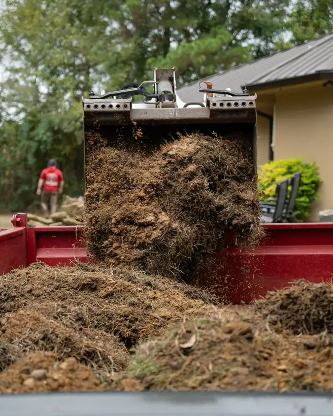 Dumping old turf and dirt into the trailer, Hallsville, TX