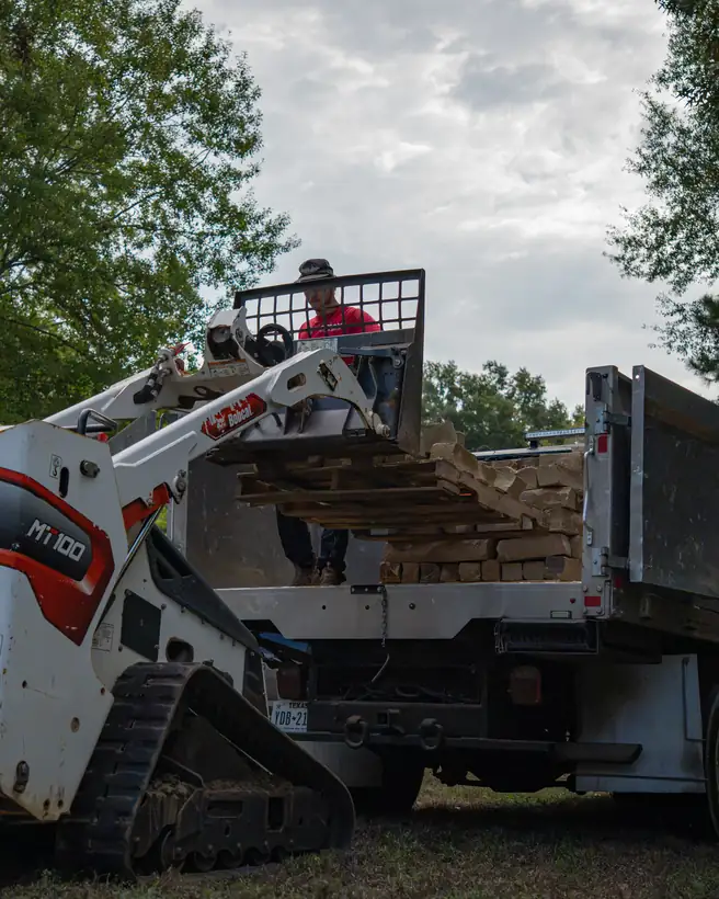 Track loader unloading stone from the truck, Hallsville, TX
