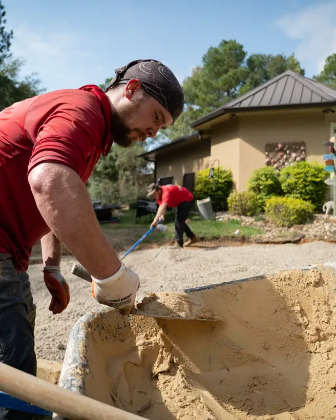 Mixing mortar in a wheelbarrow while the base goes in, Hallsville, TX
