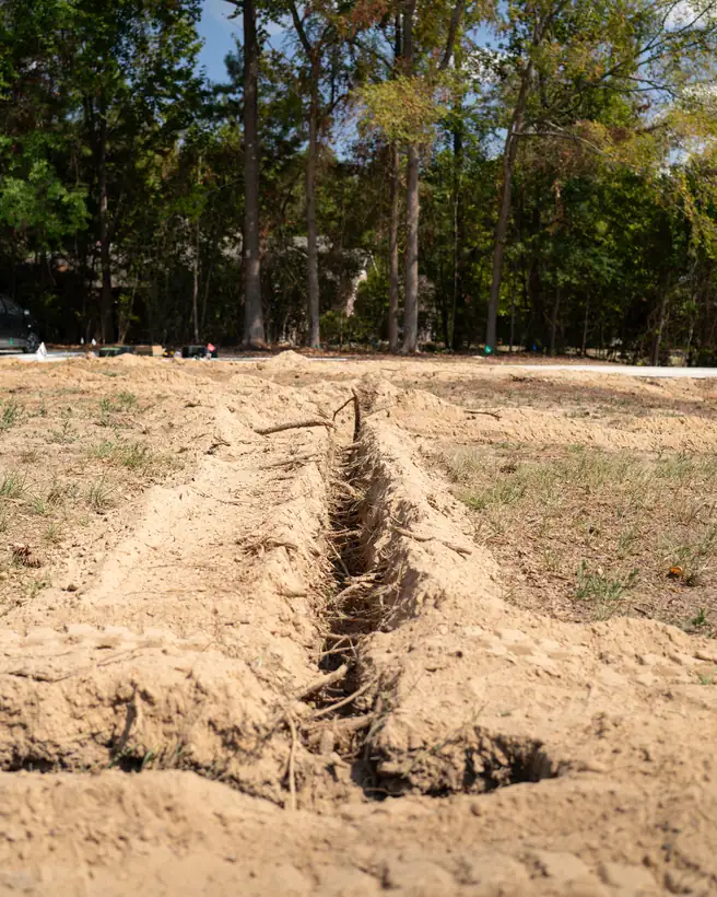 Irrigation trench dug across the bare yard, Longview, TX