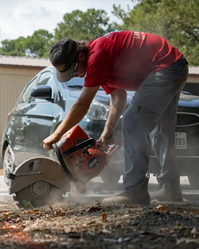 Cutting concrete with a saw to run an irrigation line, Longview, TX