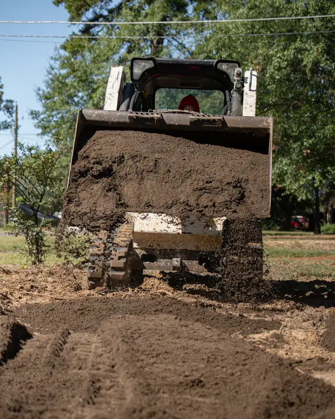 Topsoil spilling from the loader bucket, Longview, TX