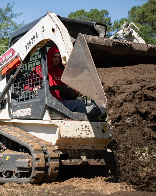 Spreading topsoil with a track loader, Longview, TX