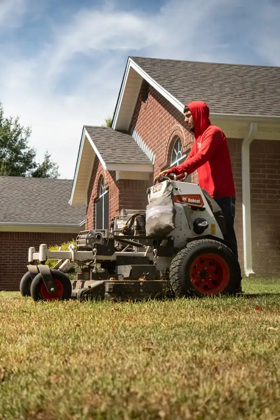 Stand-on mower on a front yard route, East Texas
