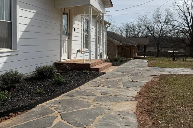 Flagstone path along a white house, East Texas