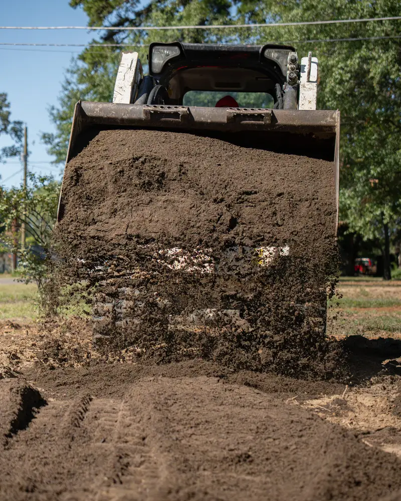 Track loader dumping topsoil, Longview, TX