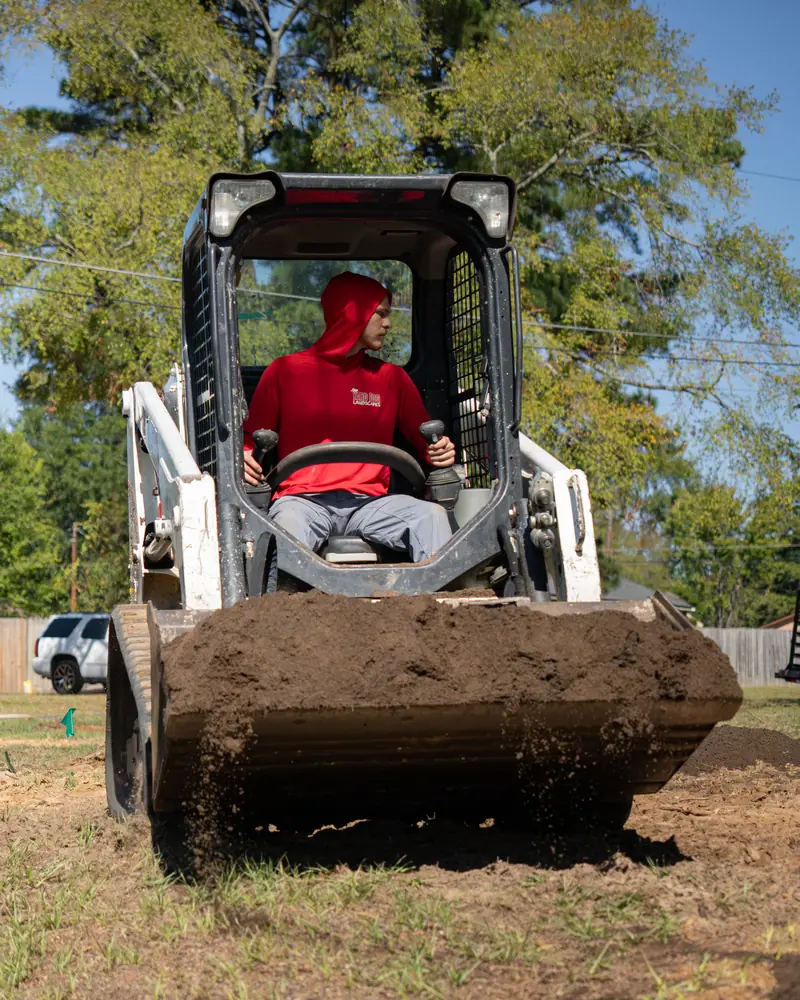 Track loader carrying topsoil in, Longview, TX