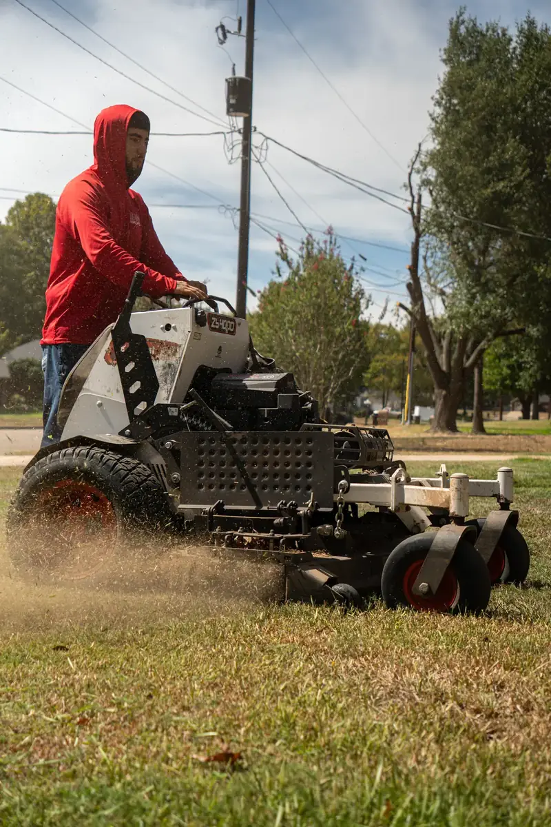 Stand-on mower cutting a lawn, East Texas